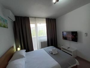 a bedroom with a bed with two white towels on it at Revolution Apartment in Baia Mare