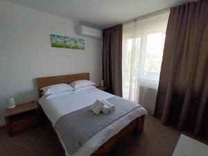 a bedroom with a bed with two towels on it at Revolution Apartment in Baia Mare