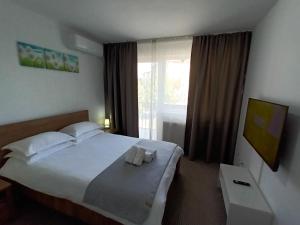 a hotel room with a bed with two towels on it at Revolution Apartment in Baia Mare