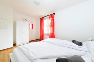 1 dormitorio con 2 camas blancas y ventana en Locarno Garden & E-scooters en Muralto