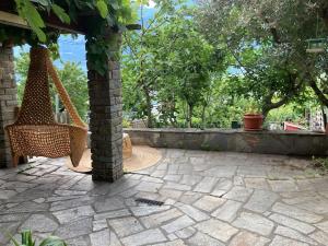 a patio with a hammock and a stone wall at Le Carnotzet in Fully
