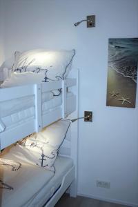 a white bunk bed with pillows and a lamp at Steinwarder 9 - Haus "Seeschwalbe" ST9 017 Steinwarder 9 in Heiligenhafen