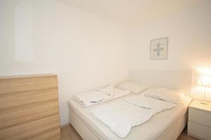 a white bed with white sheets and pillows on it at Steinwarder 1 - Haus "Seerose" ST1 055 Steinwarder 1 in Heiligenhafen