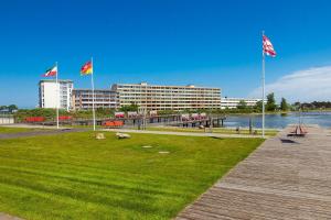 ein Park mit drei Flaggen vor einem Gebäude in der Unterkunft Steinwarder 35-37 SB4 009 Steinwarder 35-37 in Heiligenhafen