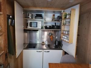 a small kitchen with a sink and a microwave at Le Carnotzet in Fully
