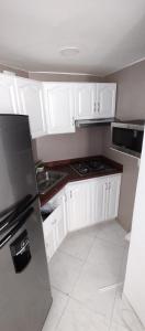 a kitchen with white cabinets and a stove top oven at Vista Playa in Cartagena de Indias