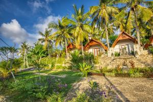 ein Resort mit Palmen und einem Gebäude in der Unterkunft Mahendra Cottage in Nusa Penida