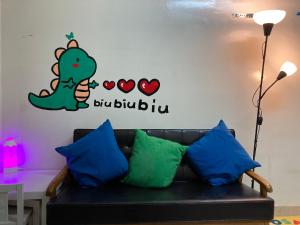 a dinosaur wall sticker in a room with a couch at YHA Ngong Ping SG Davis Youth Hostel in Hong Kong