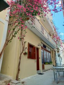 a building with a tree with pink flowers at Marw's home in Nafplio