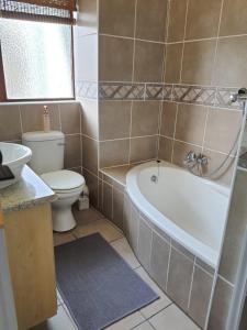 uma casa de banho com uma banheira, um WC e um lavatório. em Unit 29, Dumela Holiday Resort em Margate