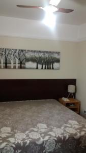 - une chambre avec un lit et une peinture murale dans l'établissement Imperial Suzano Shopping Hotel, à Suzano