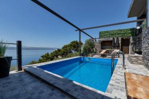 een zwembad in een huis met uitzicht op het water bij Villa Iva in Pisak