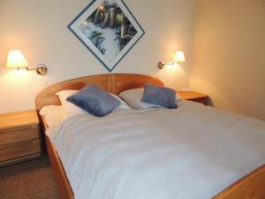 a bedroom with a large bed with two blue pillows at Dünenhof DB3 042 Dünenhof in Heiligenhafen