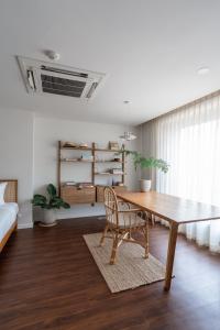 a living room with a wooden table and a chair at The Earth Hotel in Chiang Mai