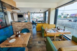 a restaurant with wooden tables and chairs and a window at Poiisse in Kolkata
