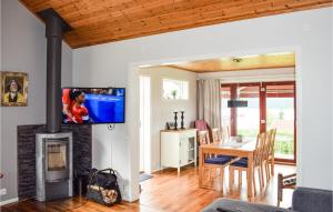 a living room with a fireplace and a dining room at Amazing Home In Nssj With House Sea View in Nässjö