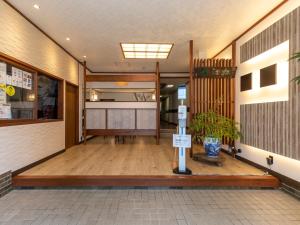 a hallway of a building with a vase on the floor at Tabist Matsuekan in Matsue
