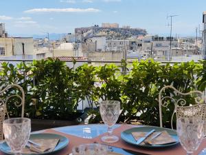 stolik z dwoma kieliszkami i widok na miasto w obiekcie 200Mbps Wifi - Penthouse With Acropolis View w Atenach