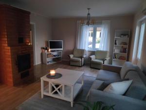 a living room with a couch and a table at Sireli hubane maja oma aia ja kaminaga in Haapsalu