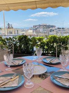 uma mesa com pratos e copos numa varanda em 200Mbps Wifi - Penthouse With Acropolis View em Atenas