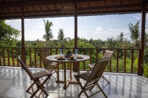 patio con mesa y sillas en el balcón en Mahendra Cottage en Nusa Penida