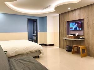 台北的住宿－水都溫泉會館，一间卧室配有一张床,墙上配有电视