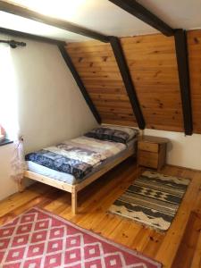 ein Schlafzimmer mit einem Bett in einem Zimmer mit Holzböden in der Unterkunft Chata Klára in Frymburk