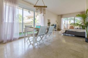 a dining room and living room with a table and chairs at La cala hills in Mijas Costa