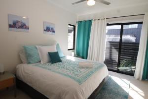 سرير أو أسرّة في غرفة في Bella Vista - Tangalooma Holiday house