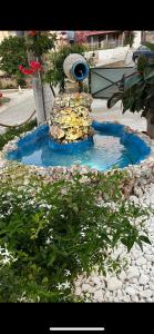 a small fountain in the middle of a garden at Ilaeira rooms in Argassi