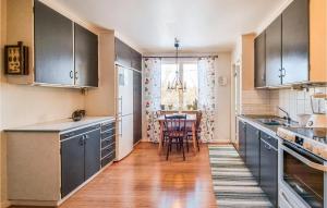 a kitchen with blue cabinets and a table in it at 3 Bedroom Gorgeous Home In Älvsered in Älvsered +11 photos