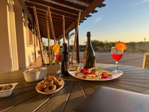 einen Tisch mit einem Teller Essen und einer Flasche Wein in der Unterkunft Tenuta Ingegna Apartments in Porto Cesareo