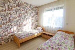 a bedroom with two beds and a wall covered in photos at Садиба під Лісом in Volovets