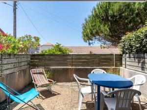 patio z krzesłami oraz niebieskim stołem i krzesłami w obiekcie Maison T3 proche plage & centre-ville avec jardinet et parking - FR-1-521-200 w mieście Biscarrosse +2 zdjęcia