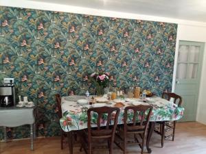 a dining room with a table with chairs and a floral wallpaper at Le Chalange in Lapenty