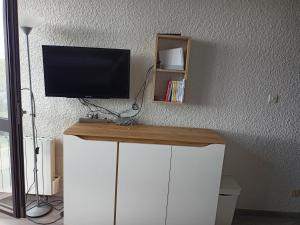 a desk with a television on top of a wall at Résidence cambielh in Aragnouet