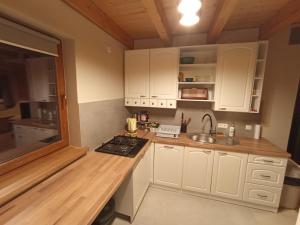 una cocina con armarios blancos y fregadero en Domek w Cisnej pod Honem 2, en Cisna