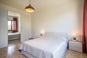 um quarto com uma grande cama branca e um espelho em Casa vacanze Bergamo em Cavallino-Treporti