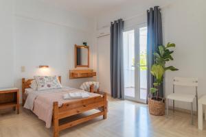 1 dormitorio con cama y ventana grande en Kantaros Apartments, en Ýpsos