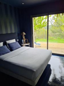1 dormitorio con 1 cama grande y puerta corredera de cristal en villa moderne, en Saint-Gély-du-Fesc