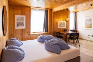 a bedroom with two beds and a table and a window at Seehotel Sternen in Brienz