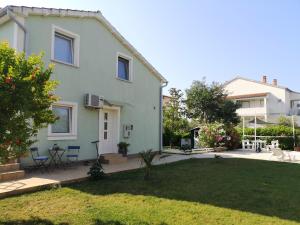 a white house with a yard with a yard at Chillout Apartments with Pool Patricia in Fažana