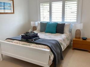 1 dormitorio con cama con almohadas y ventana en Family Getaway to Manly Beach plus free onsite parking, stroll to beach, cafes en Sídney