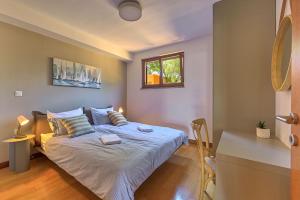 een slaapkamer met een bed met blauwe lakens en een raam bij Apartment Zala with private pool in Ližnjan