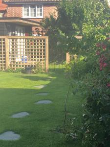 a backyard with a fence and a yard with grass at Pretty self-contained garden room in Sheringham