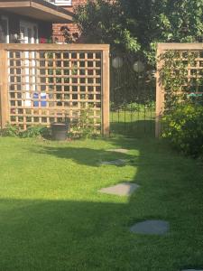 a yard with a wooden fence and grass at Pretty self-contained garden room in Sheringham