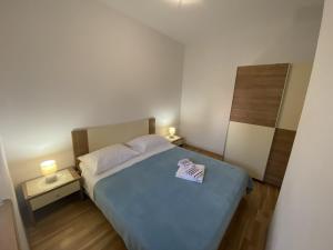 a bedroom with a blue bed with two lamps at Apartments Zvonimir in Privlaka