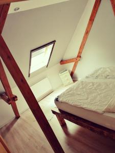 a attic bedroom with a bed and a window at FeWo an der Eider / Holiday apartment on the Eider in Sankt Annen