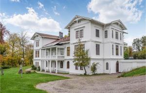 a large white house with a yard at Stunning Apartment In Trans With Kitchen in Tranås