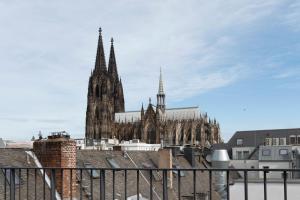 una catedral con torretas y agujas en una ciudad en Legend Hotel en Colonia